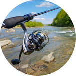 a spinning fishing rod with a river in the background.	